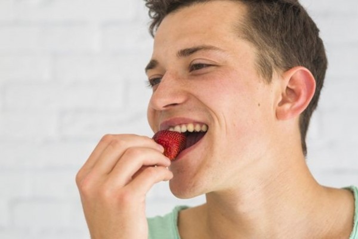 Человек ест клубнику